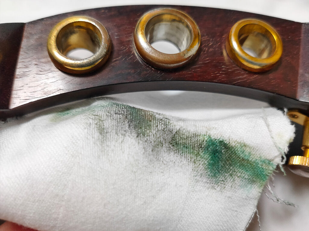 研磨剤を付けた布で津軽三味線の福林を磨くと青サビ（緑青）が取れた